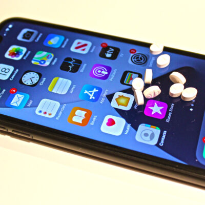 A smartphone will prescription drugs sitting on top of the screen